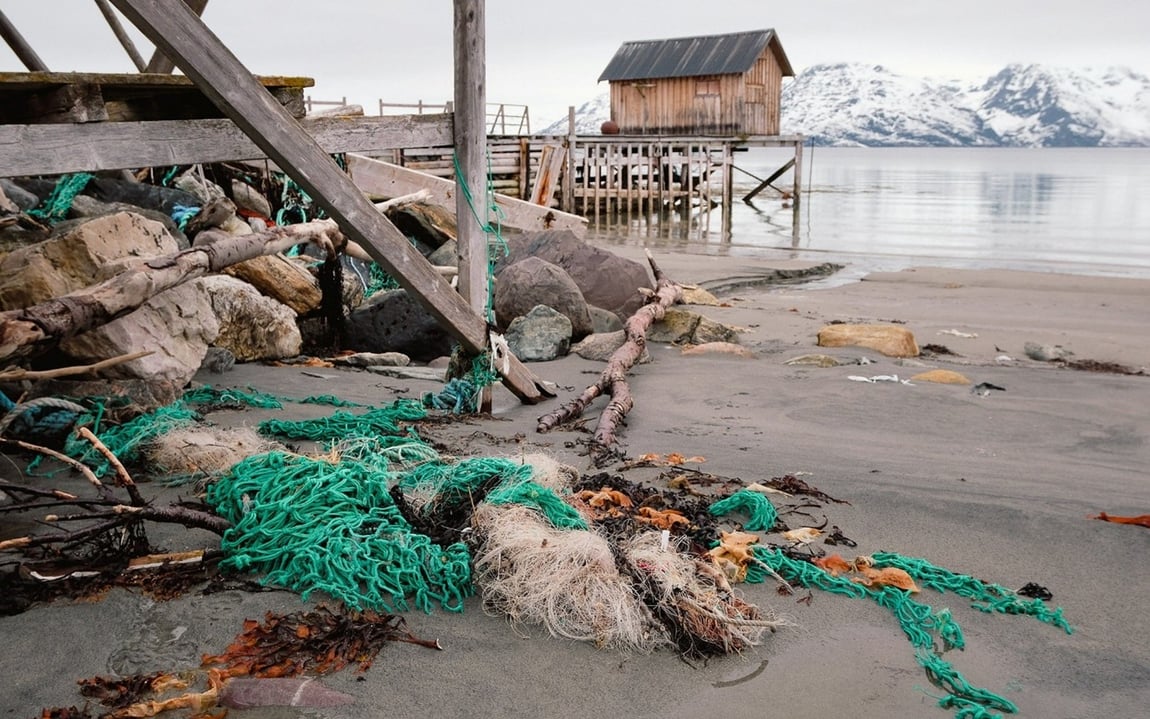 Foto av søppel som ligg på ei strand.